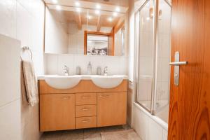 a bathroom with two sinks and a shower at Turuwang Penthouse by HomeFlow in Zermatt
