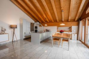 a kitchen and dining room with a wooden ceiling at Turuwang Penthouse by HomeFlow in Zermatt