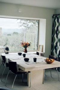 ein Esstisch mit Stühlen und ein großes Fenster in der Unterkunft Les Milles Roches in Gordes + 39 Fotos