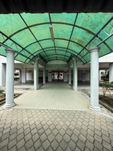 an empty building with a green ceiling and pillars at AJ Homestay Muar in Muar