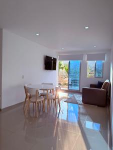 een woonkamer met een tafel, stoelen en een bank bij Apartamento con piscina y Aire Acondicionado en Anapoima centro in Anapoima