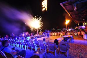 eine Menschenmenge, die auf Stühlen am Strand mit Feuerwerk sitzt in der Unterkunft Twin Palms Hostel Phi Phi in Ko Phi Phi
