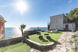 een tuin met stoelen en de oceaan op de achtergrond bij Villa 4 bedroom Vista Mare, Terrazza e Giardino in Genua