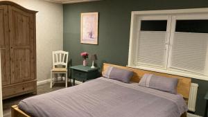 ein Schlafzimmer mit einem großen Bett und einem Stuhl in der Unterkunft Waldgeflüster in Buchholz in der Nordheide