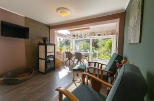 ein Wohnzimmer mit Kamin und ein Esszimmer in der Unterkunft Waldgeflüster in Buchholz in der Nordheide