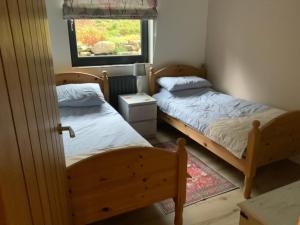 twee bedden in een kleine kamer met een raam bij Carrick Chalets -2 in Carrick
