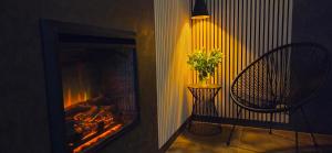 a room with a fireplace with a chair and a table at GreenHouse pool & spa in Otruševec