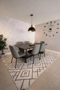 una sala da pranzo con tavolo e sedie su un tappeto di Vacation QJR a Cutler Bay