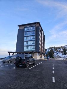 a car parked in a parking lot in front of a building at Apartman Blue Sky in Jahorina