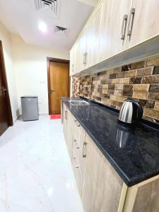 een keuken met een spoelbak en een aanrechtblad bij Royal Building in Ras al Khaimah