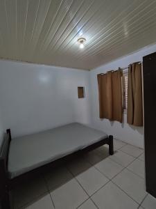 een kamer met een bed in de hoek van een kamer bij Kitnet em Arroio do Sal in Arroio do Sal