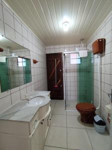 een badkamer met een wastafel, een toilet en een douche bij Kitnet em Arroio do Sal in Arroio do Sal