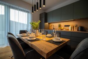 een eettafel met stoelen en een keuken bij Apartmány Horizont in Loučná pod Klínovcem +104 foto's