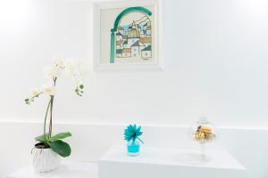 Eine weiße Theke mit zwei Vasen und einem Bild an der Wand in der Unterkunft Porta della costiera in Vietri