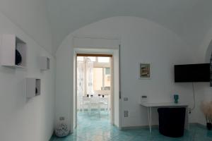 ein weißes Zimmer mit einem Tisch und einem Fenster in der Unterkunft Porta della costiera in Vietri