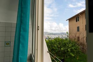 La fenêtre de la salle de bains donne sur un bâtiment. dans l'établissement Porta della costiera, à Vietri