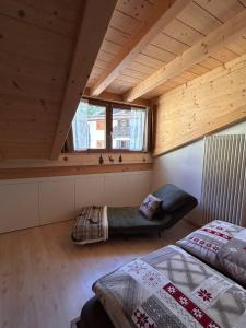 a attic room with a bed and a window at Alpen Lodge Predazzo in Predazzo