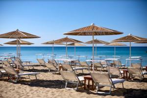a group of tables and chairs on a beach with umbrellas at Ada&niní in Galatina
