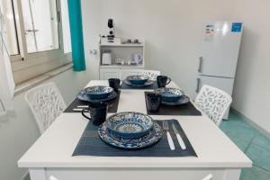 a white table with blue and white plates on it at Porta della costiera in Vietri sul Mare