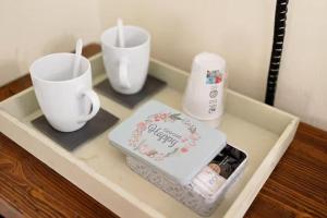 un tavolo con due tazze e una torta sopra di Residenza Amé Peschiera del Garda a Peschiera del Garda