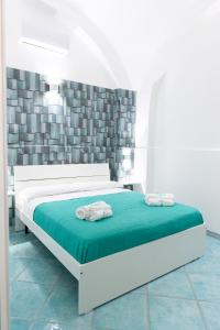 - une chambre avec un lit blanc et une couverture verte dans l'établissement Porta della costiera, à Vietri