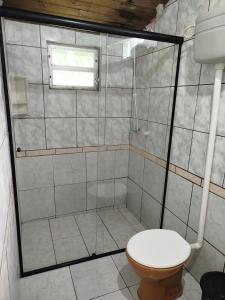 a bathroom with a shower with a toilet and a window at Chácara Betel in Rancho Queimado +18 photos