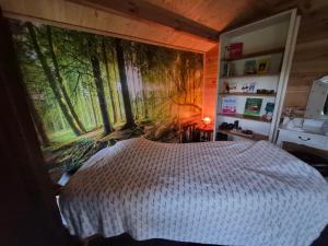a bedroom with a large mural of trees on the wall at Ferienwohnung Thomée - Ruhig gelegen, ideal für Monteure und Erholungssuchende in Looft