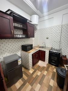 a kitchen with wooden cabinets and a stove top oven at Fadilimmo 009 in Yaoundé +2 photos
