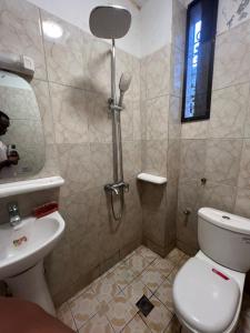a bathroom with a shower with a toilet and a sink at Fadilimmo 009 in Yaoundé