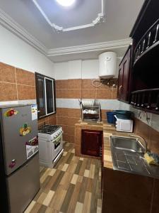 a kitchen with a refrigerator and a sink at Fadilimmo 009 in Yaoundé
