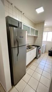 une cuisine avec un réfrigérateur en acier inoxydable dans l'établissement Residencial Ibis, à Bauru