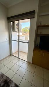 une pièce avec une porte coulissante en verre avec une télévision dans l'établissement Residencial Ibis, à Bauru 5 autres photos