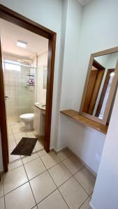 une salle de bain avec toilettes et miroir dans l'établissement Residencial Ibis, à Bauru