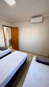 une chambre avec deux lits dans une chambre dans l'établissement Residencial Ibis, à Bauru