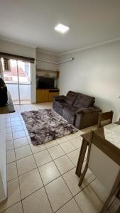 un salon avec un canapé et un tapis dans l'établissement Residencial Ibis, à Bauru