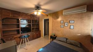 een woonkamer met een bank en een plafondventilator bij Santafe Minisuites in Hermosillo