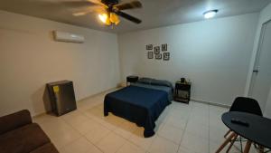 een slaapkamer met een bed en een plafondventilator bij Santafe Minisuites in Hermosillo