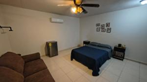 een woonkamer met een bed en een bank bij Santafe Minisuites in Hermosillo