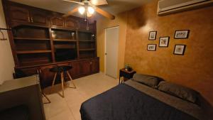 een slaapkamer met een bed en een plafondventilator bij Santafe Minisuites in Hermosillo +35 foto's