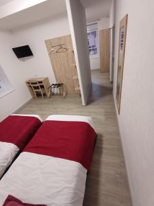 een slaapkamer met een rood-wit bed en een gang bij Le Saint Germain in Saint-Germain-du-Bois