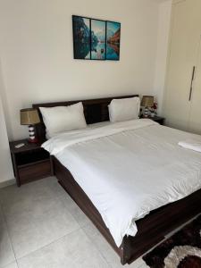 een slaapkamer met een groot bed met witte lakens bij Nova by Devtraco plus in Accra