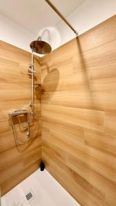 La salle de bains est pourvue d'une douche et de murs en bois. dans l'établissement Casa Kiara, à Domodossola