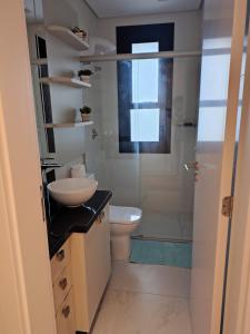 een badkamer met een toilet, een wastafel en een douche bij Sinta se em casa, mas, com sol e mar in Torres +17 foto's