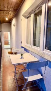 une table et des chaises dans une pièce avec des fenêtres dans l'établissement Casa Kiara, à Domodossola