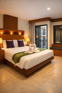 una camera da letto con un letto grande con asciugamani sopra di Prisha Inn a Patong Beach