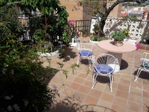 eine Terrasse mit einem Tisch und Stühlen sowie einem Tisch und Stühlen in der Unterkunft Cuencaloft el patio de Pipo in Cuenca