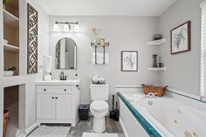 a bathroom with a tub and a toilet and a sink at Haven Oasis in Nampa +36 photos