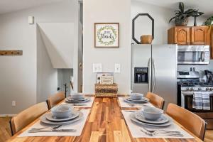 a dining room with a table with chairs and a refrigerator at Haven Oasis in Nampa