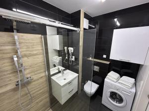 une salle de bain avec un lavabo et une machine à laver dans l'établissement Stay Apartment, à Varsovie 20 autres photos