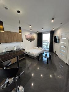 un salon avec un lit et une cuisine dans l'établissement Stay Apartment, à Varsovie
